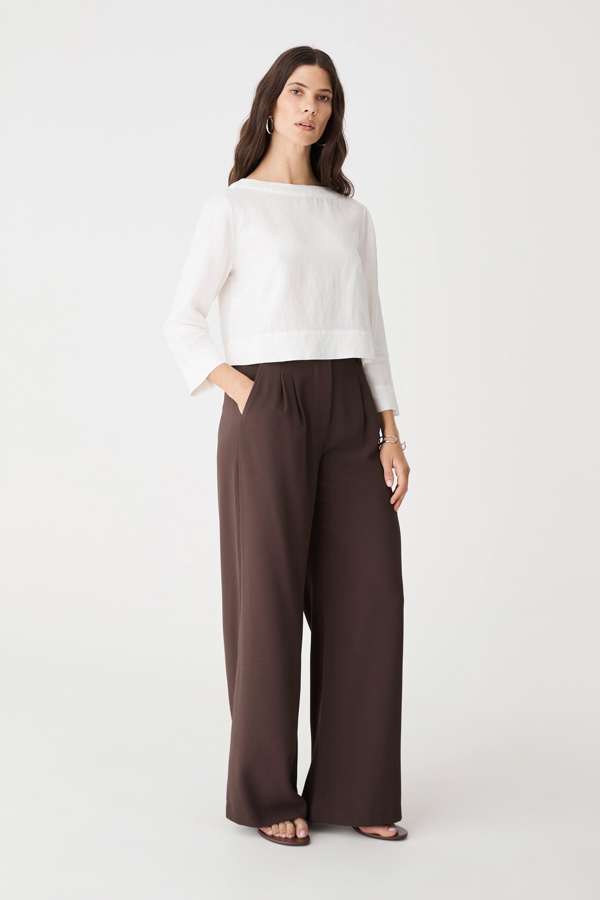Front view of the chocolate wide leg pants with hands in pockets