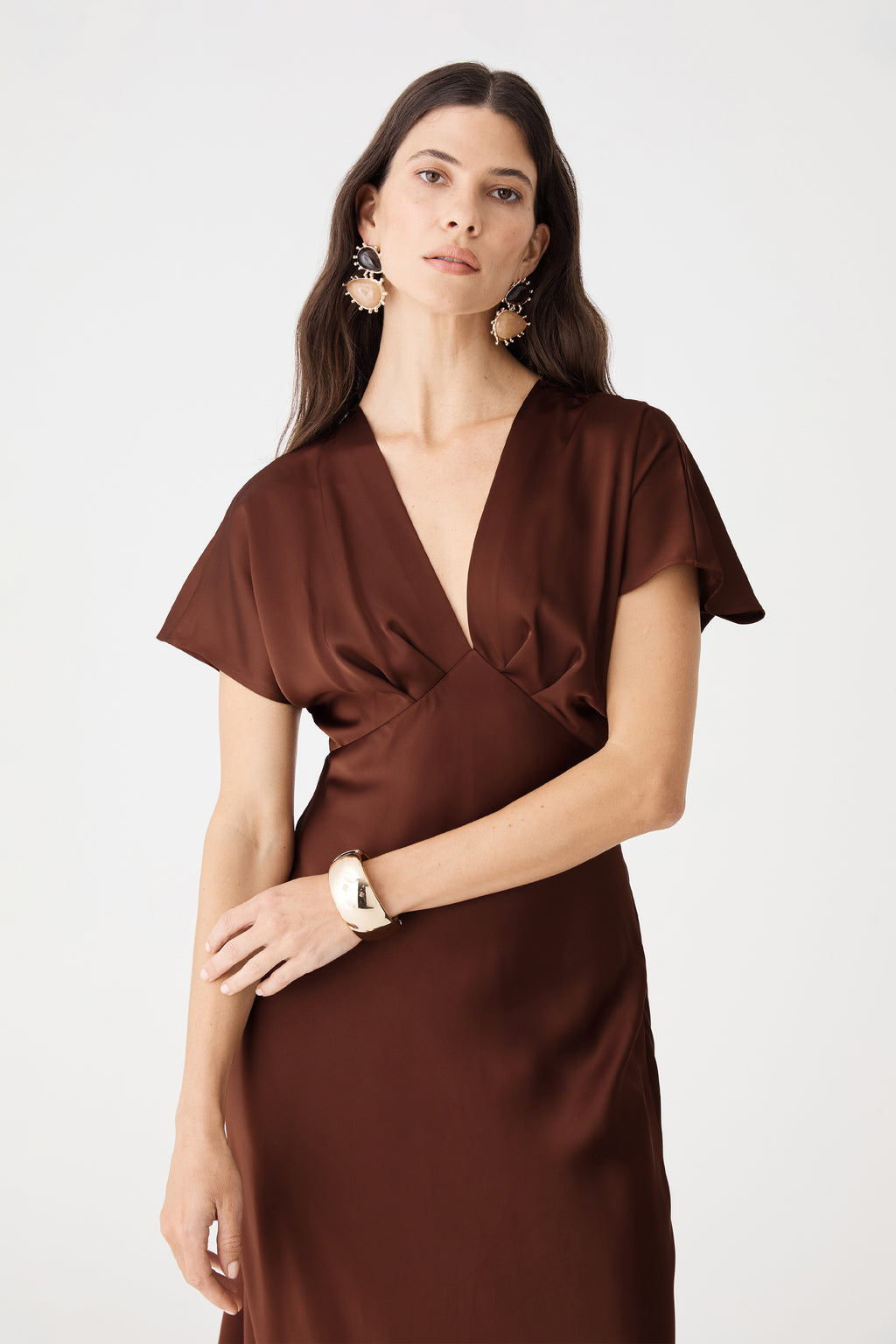 Close-up of the V-neckline, batwing sleeve and fitted waist in brick satin