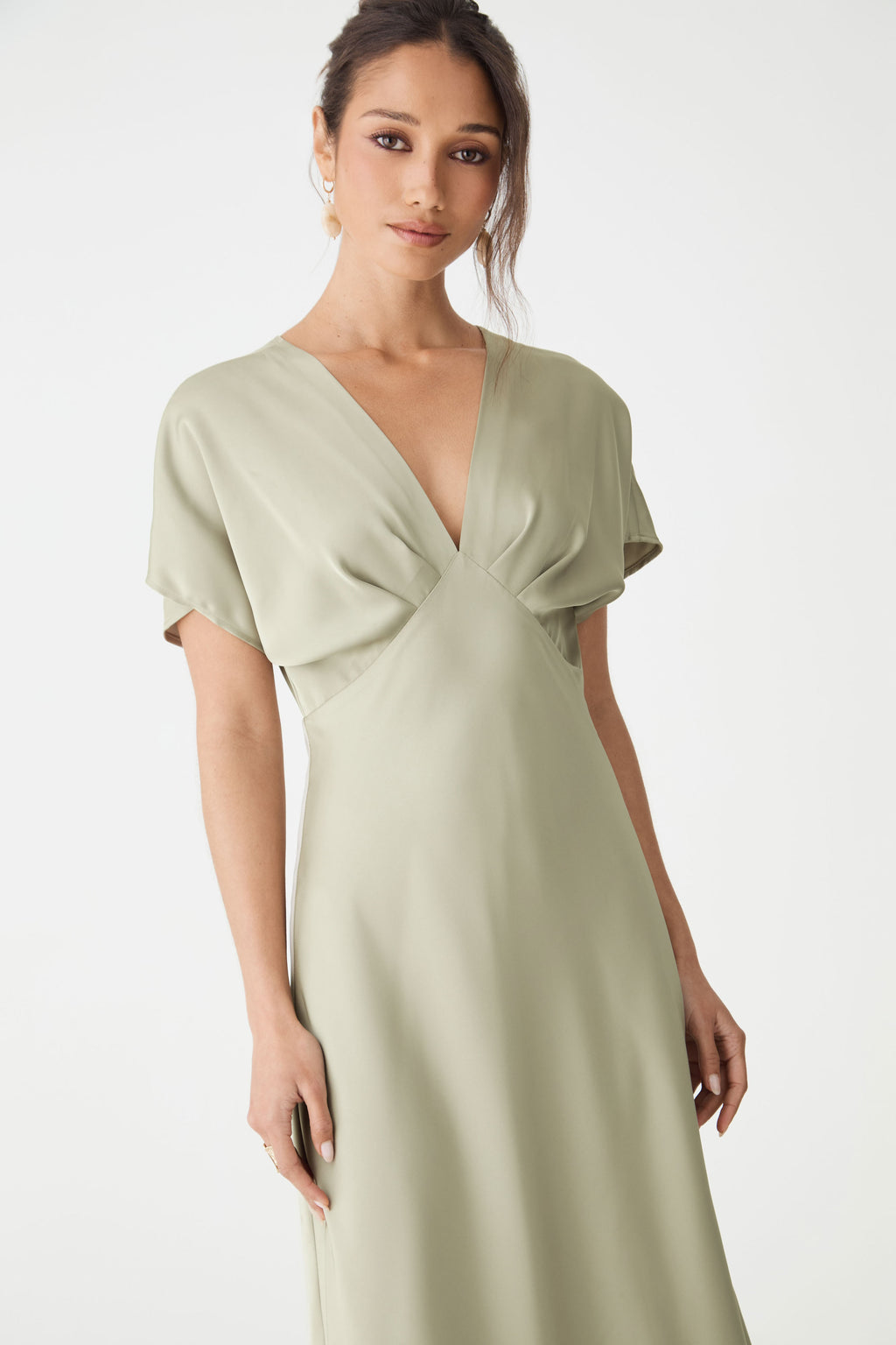 Close-up of the V-neckline, short batwing sleeves and fitted waist in sage satin