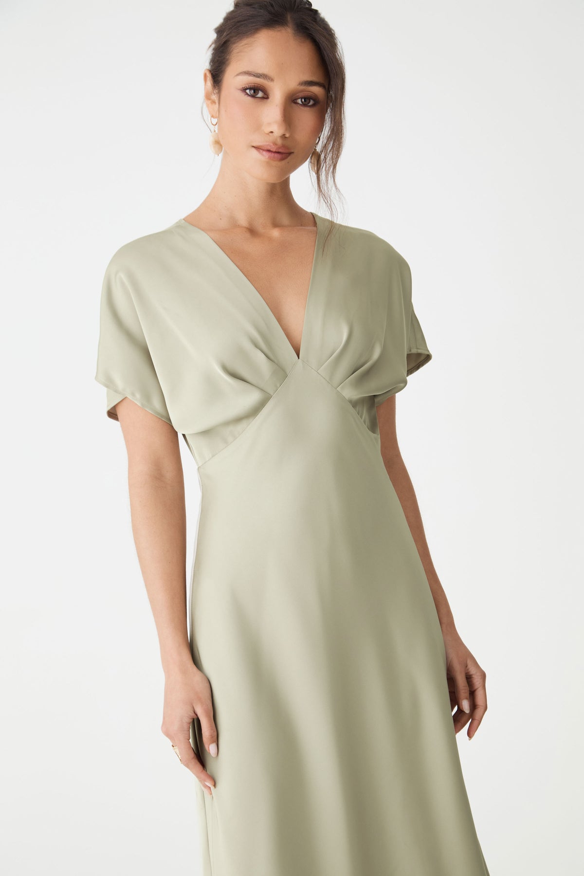 Close-up of the V-neckline, short batwing sleeves and fitted waist in sage satin