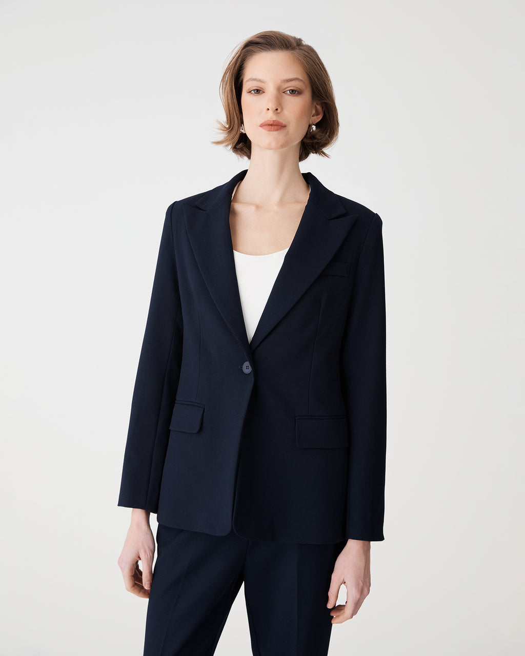 Front view of the navy blazer buttoned over a white top
