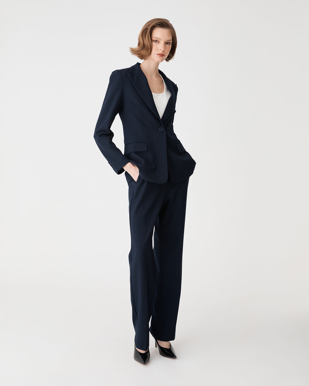 Merid Single Breasted Blazer in navy, side-on full-length view worn with matching navy tailored pants
