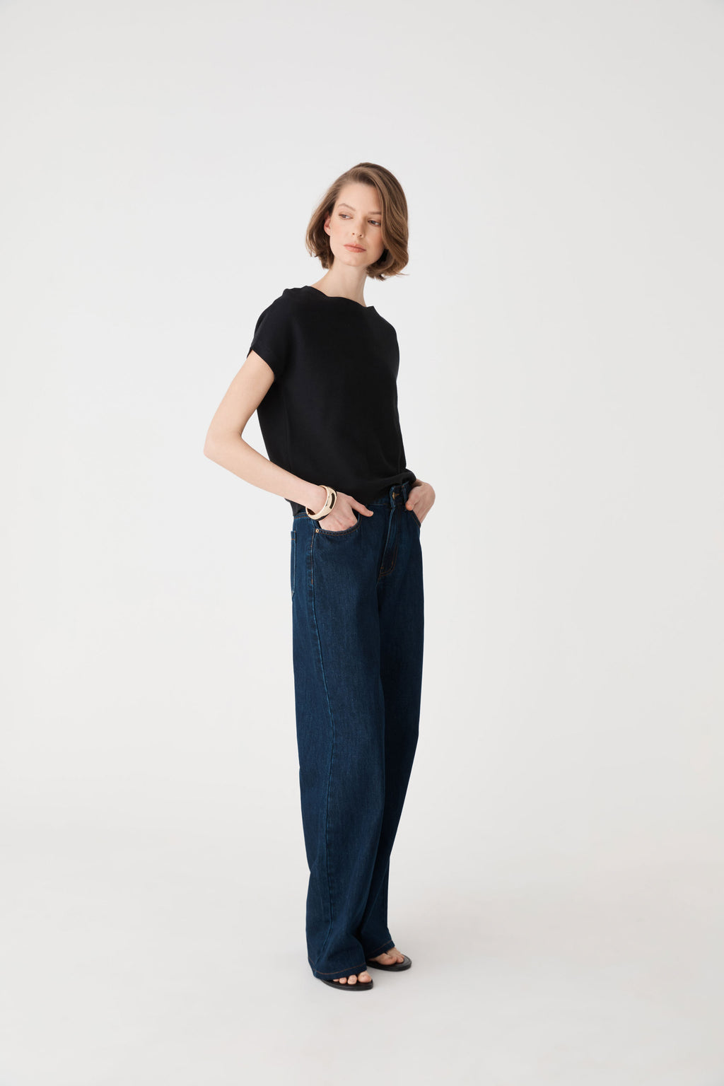 Side view of the black knit top with dark blue jeans
