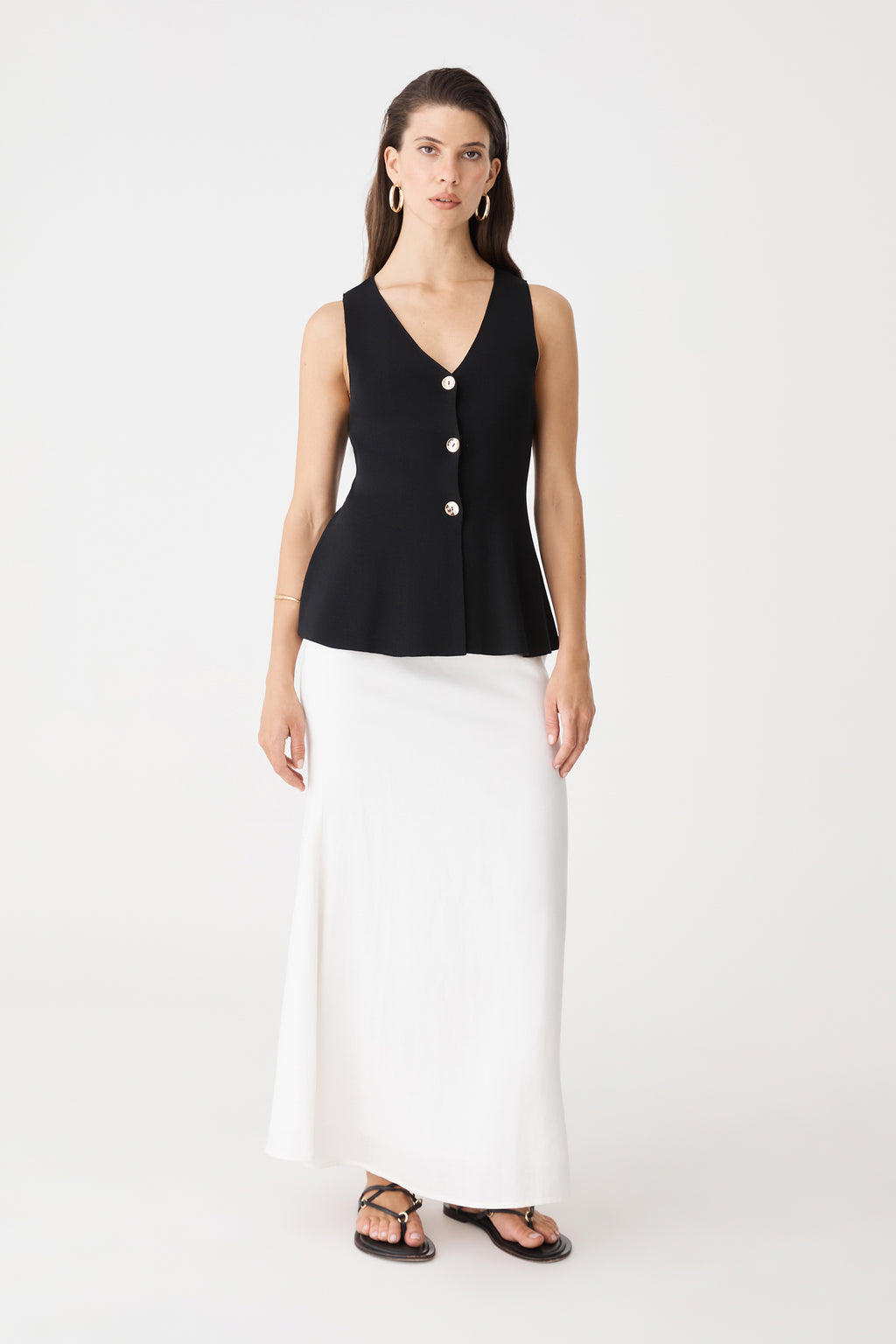 Valerie Button Peplum Knit Top in black, front view worn with a white maxi skirt