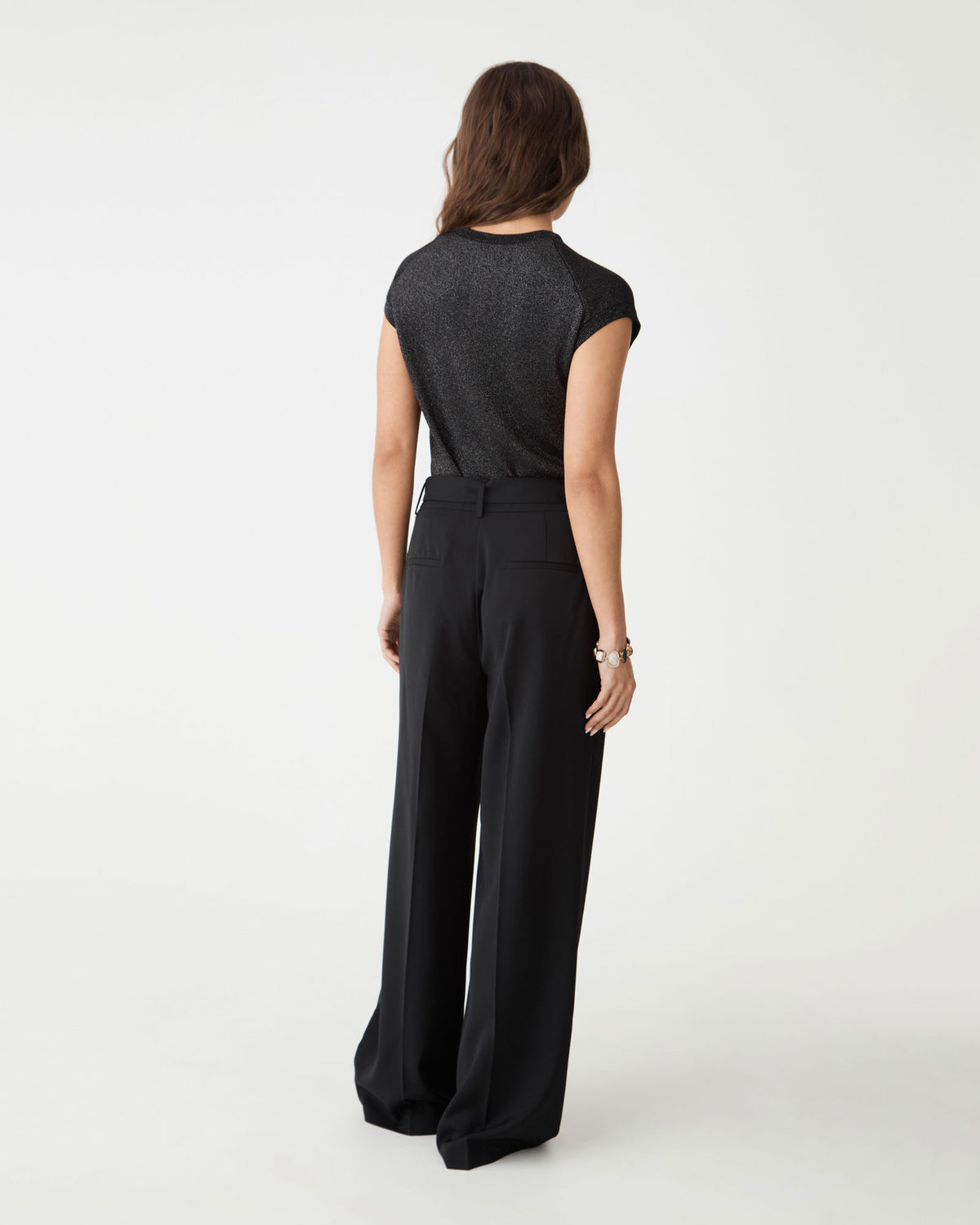 Back view of the black Saskia Lurex Knit Top with black wide-leg trousers