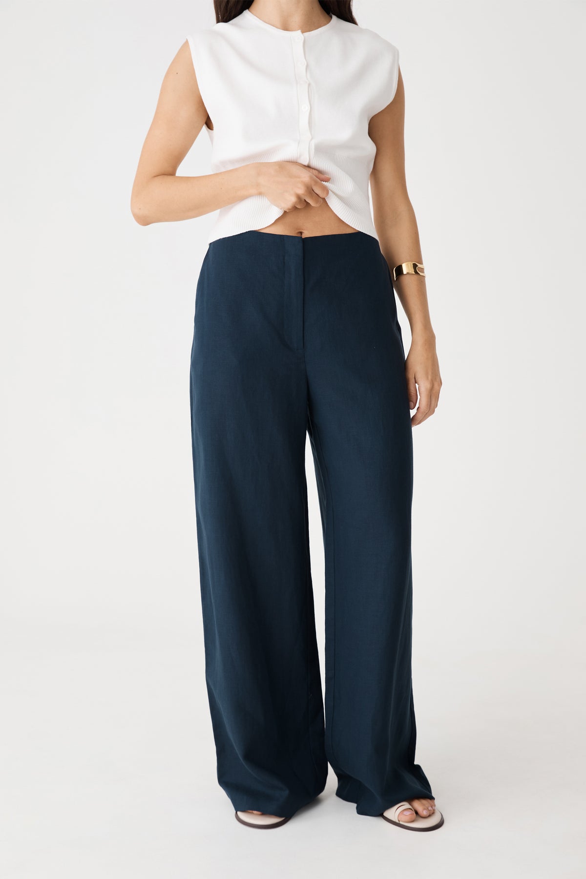 Close-up front view of the navy high-waisted wide-leg pants showing waistband and zip fly