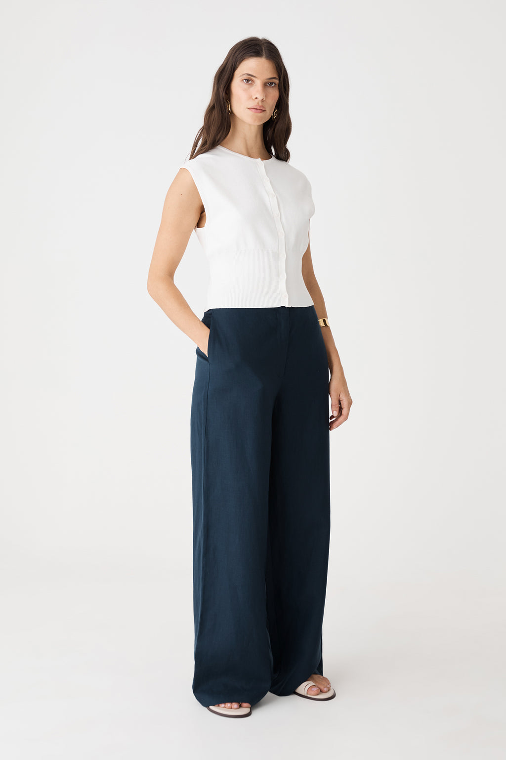 Side view of the navy wide-leg pants showing in-seam side pocket and full-length drape