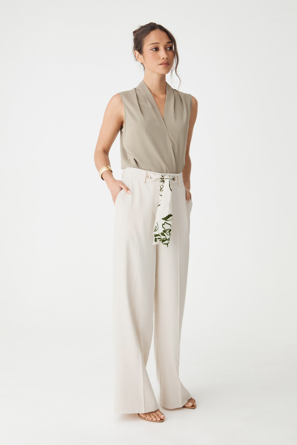 Front view of the cream wide-leg pants worn with hands in side pockets