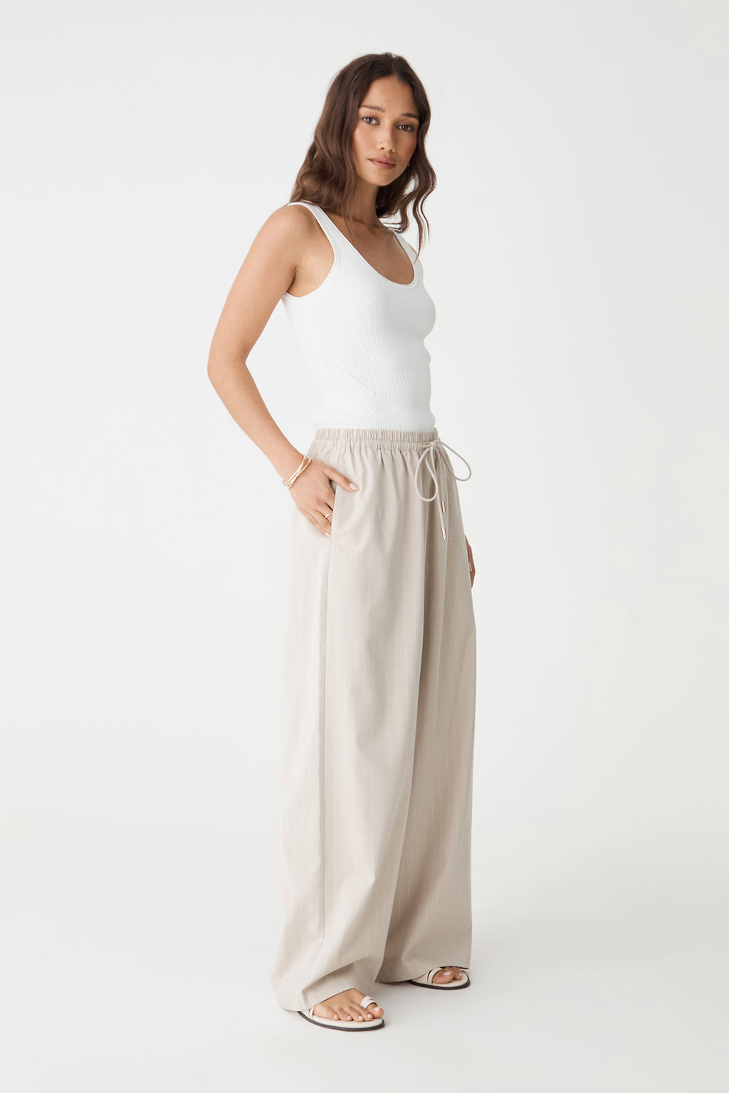 Side view of the beige pinstripe wide-leg pants