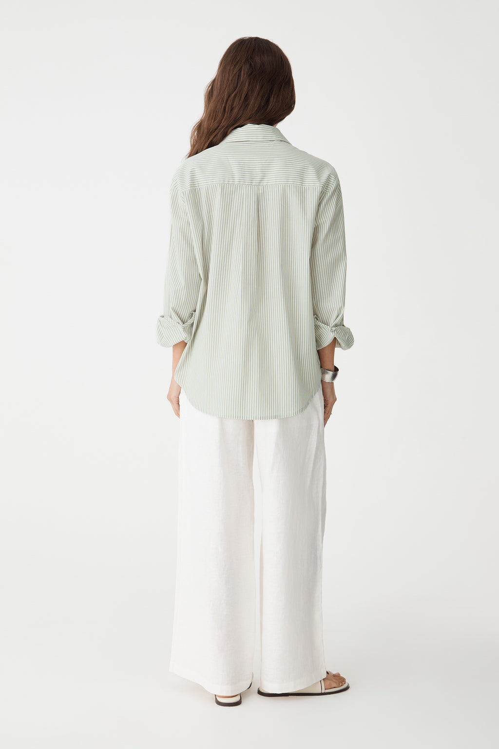 Back view of the green stripe shirt with white wide-leg trousers