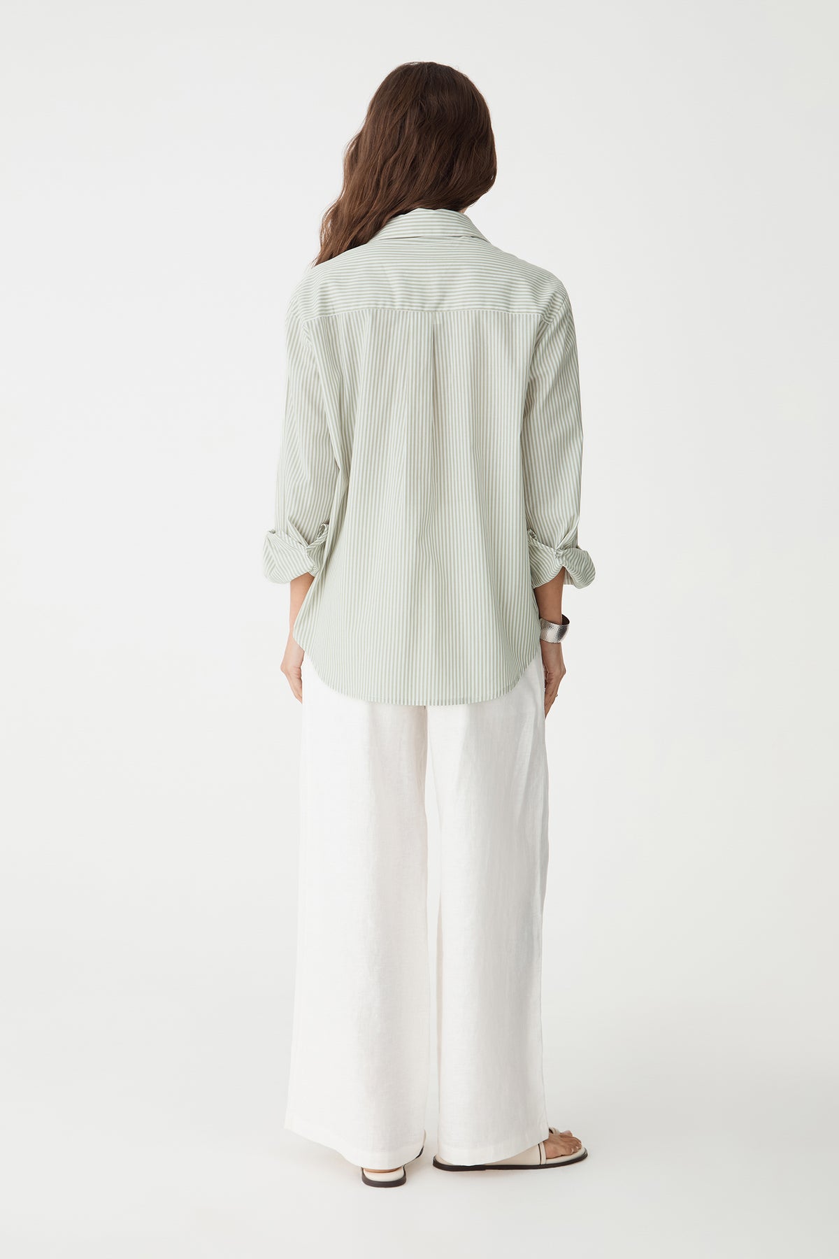 Back view of the green stripe shirt with white wide-leg trousers