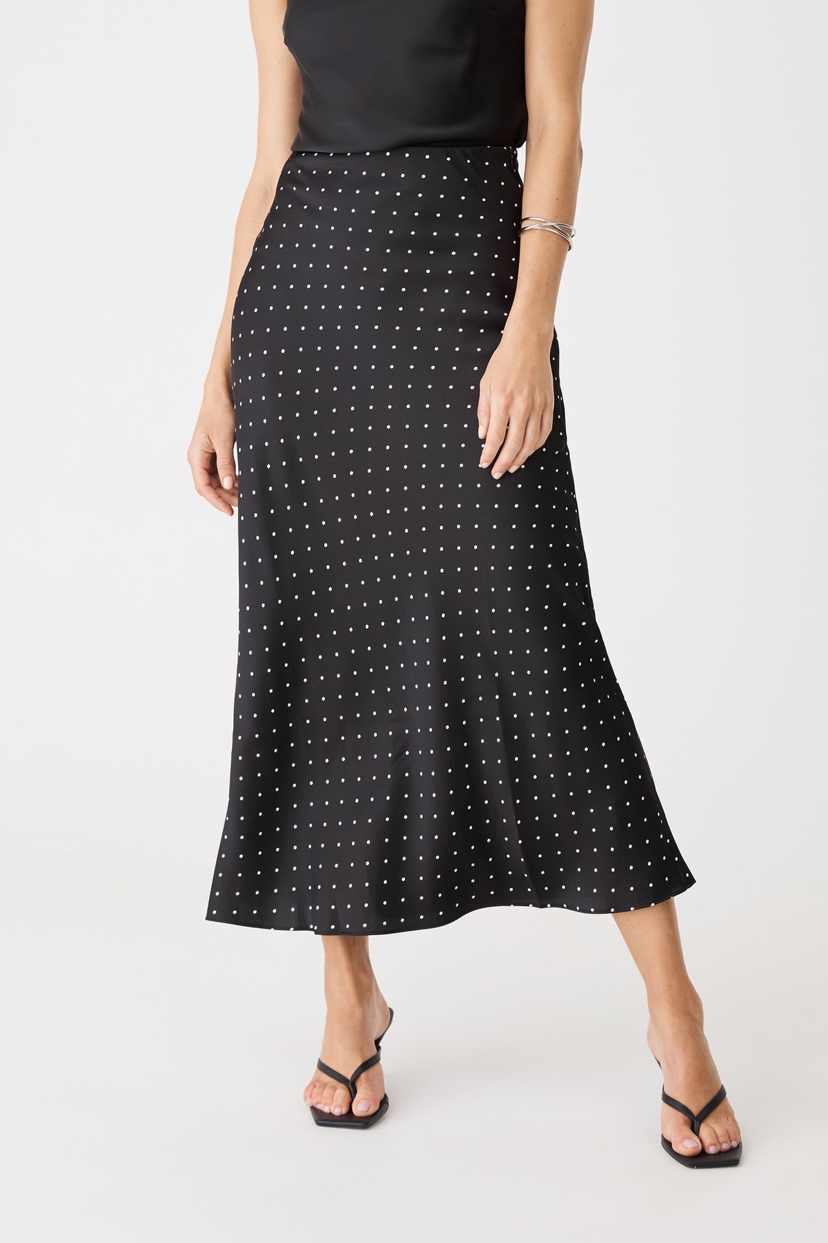 Close-up of the polka dot skirt front, showing high-rise waistband and midi length