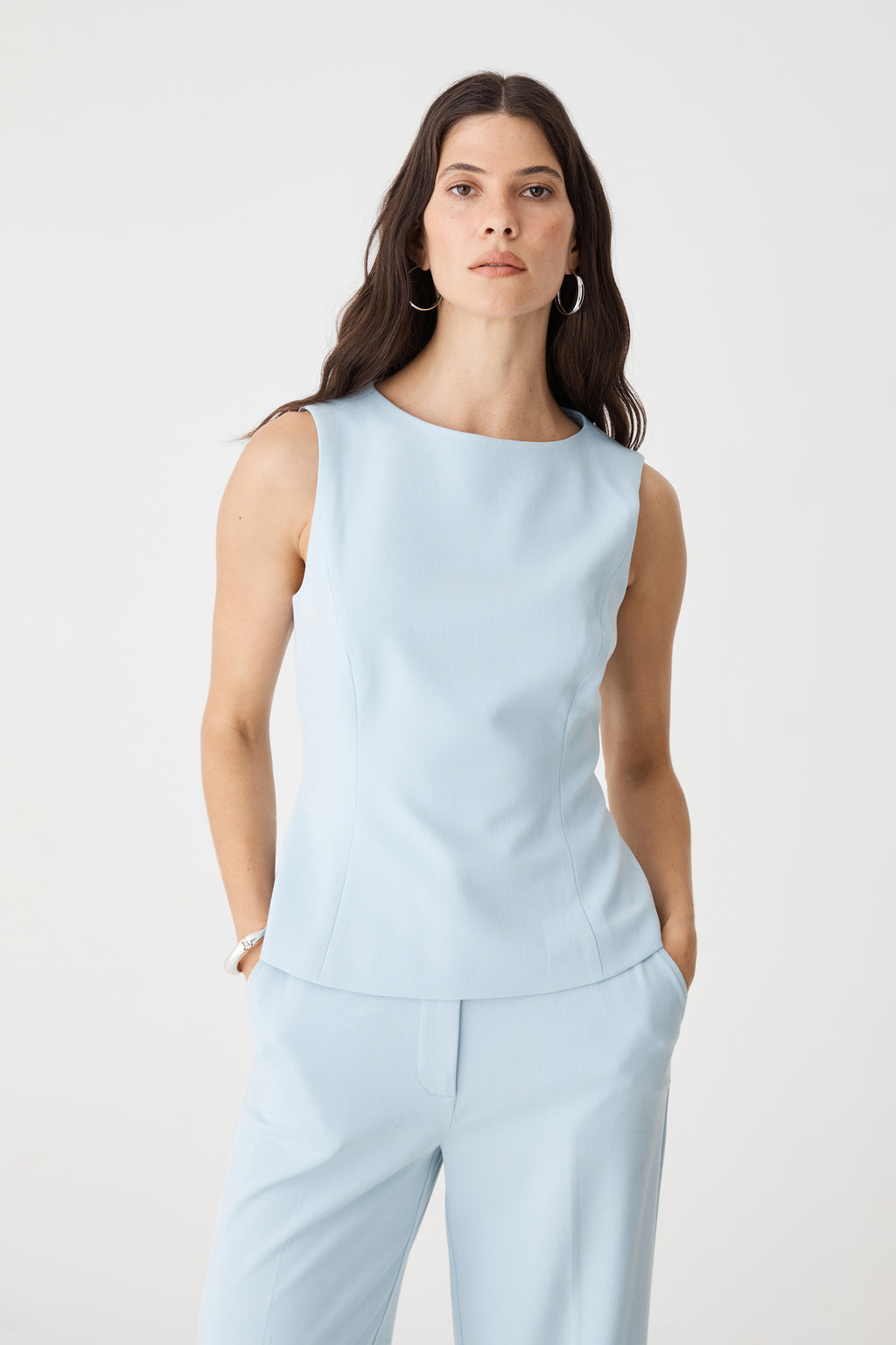 Front close-up of the sky blue Melanie Tailored Top showing high boat neckline and panel seams
