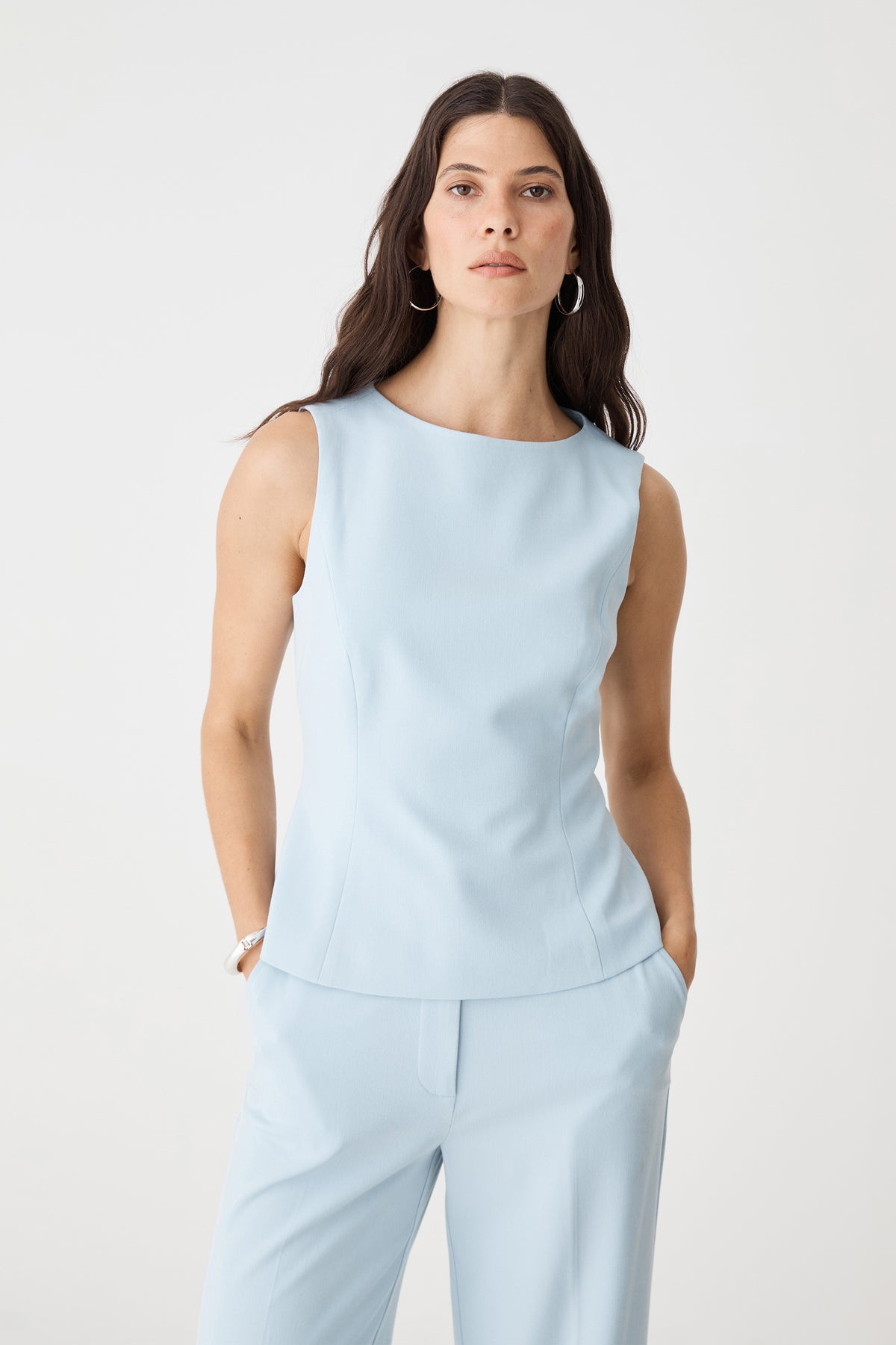 Front close-up of the sky blue Melanie Tailored Top showing high boat neckline and panel seams