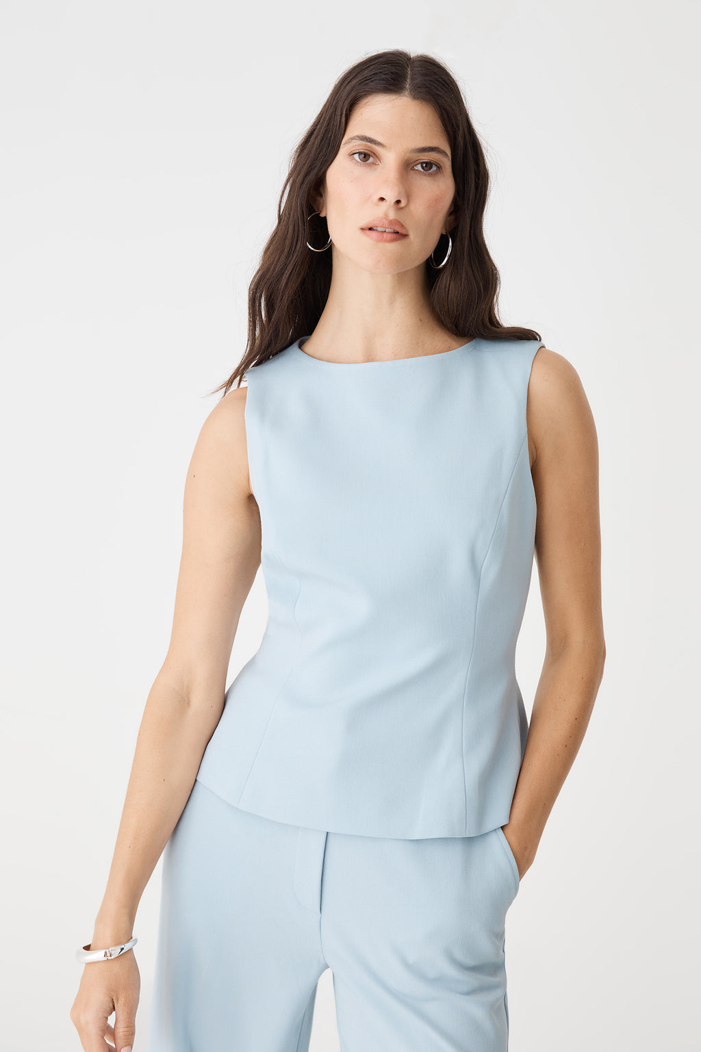 Three-quarter front view of the sky blue Melanie Tailored Top, sleeveless with flared hem