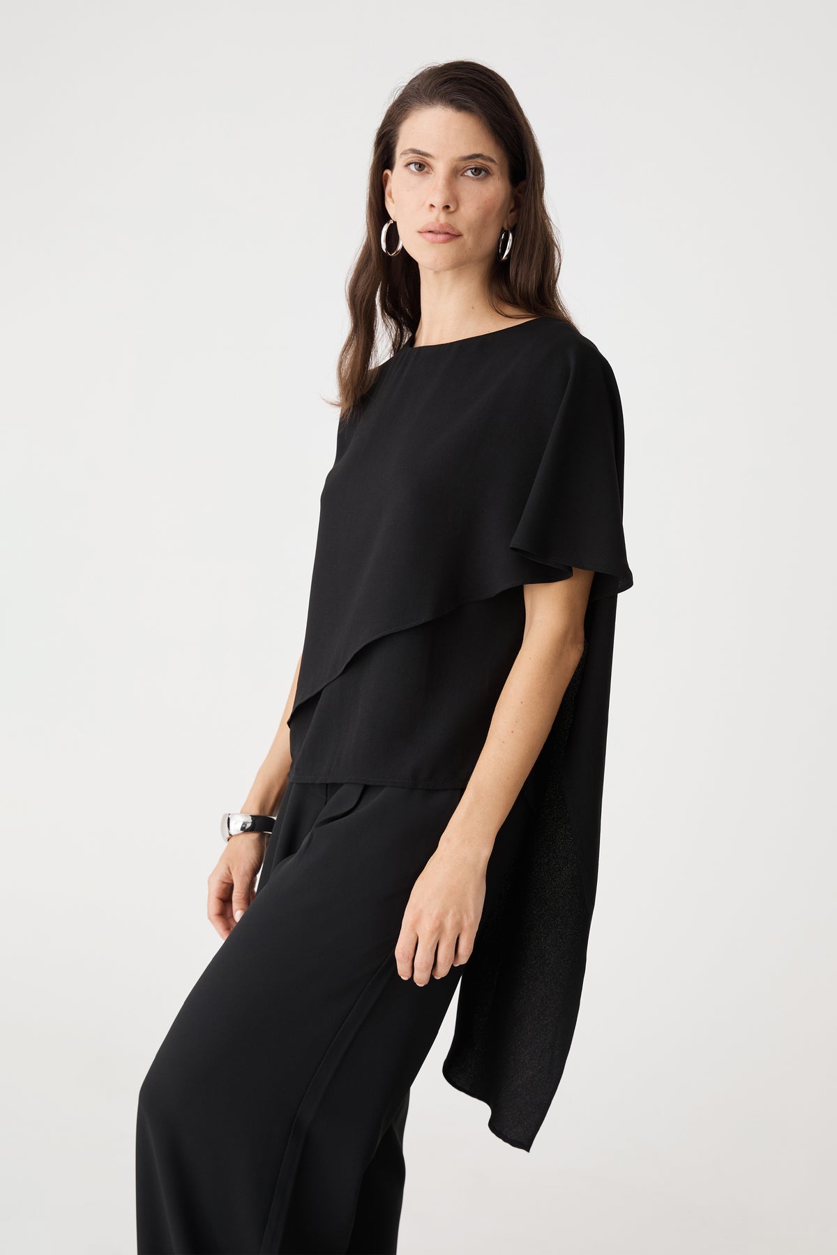Side view showing the black cape overlay draping over one shoulder