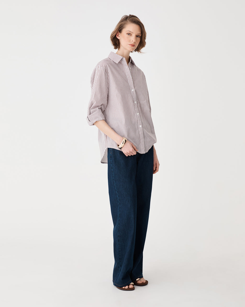 Angled full-length view of the brown stripe shirt with curved shirttail hem