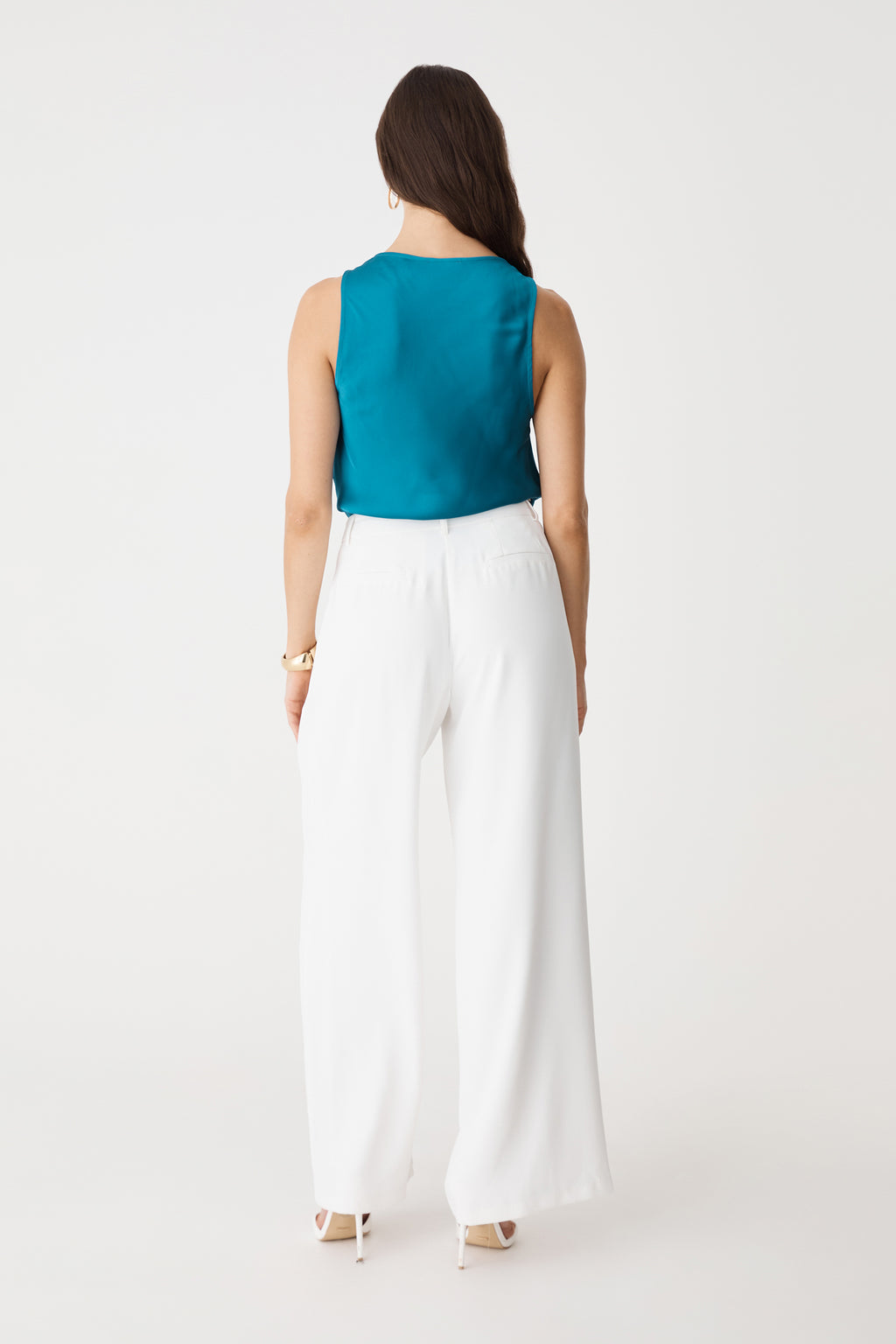 Back view of the aquamarine satin top with white wide-leg trousers