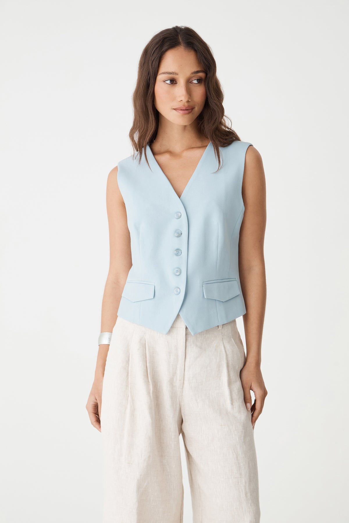 Close-up front view of the sky blue vest showing V-neckline and five-button closure