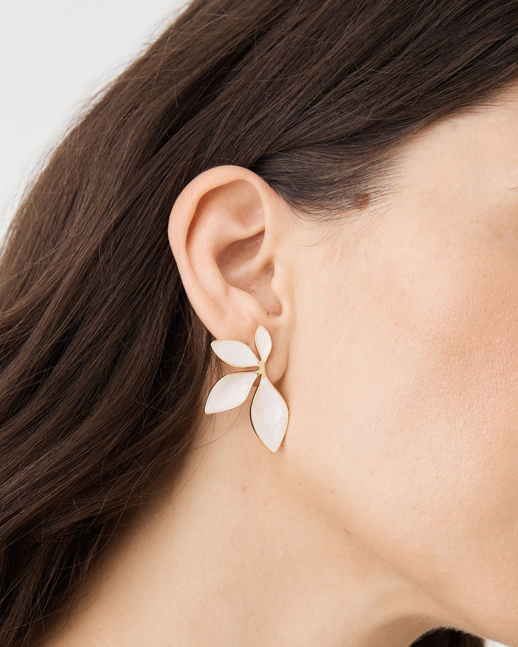Martina Petal Earrings in pearlescent white with gold-tone edging, close-up worn on ear