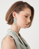 Lina Bloom Drop Earrings in aqua, three-flower cascade drop worn with a sage green top, side view