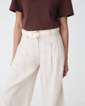 Elena Crochet Belt in ivory with round gold-tone buckle, worn at the waist with linen trousers and brown tee