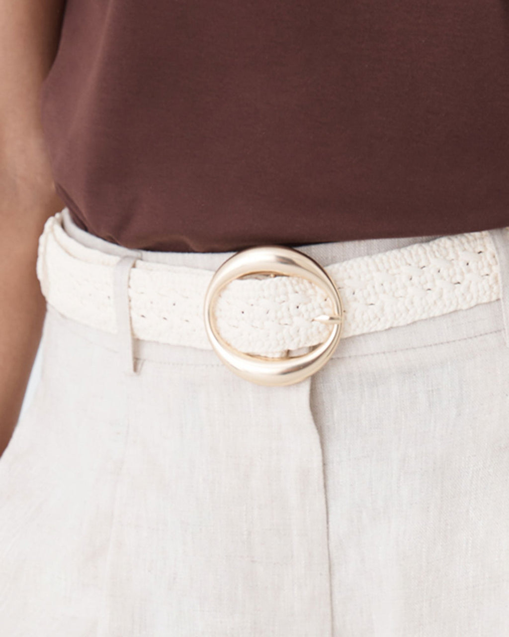 Close-up of the openwork crochet strap and round gold-tone buckle