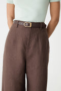 Rue Leather Belt in dark brown worn through the waistband of brown wide-leg pants, close-up front view
