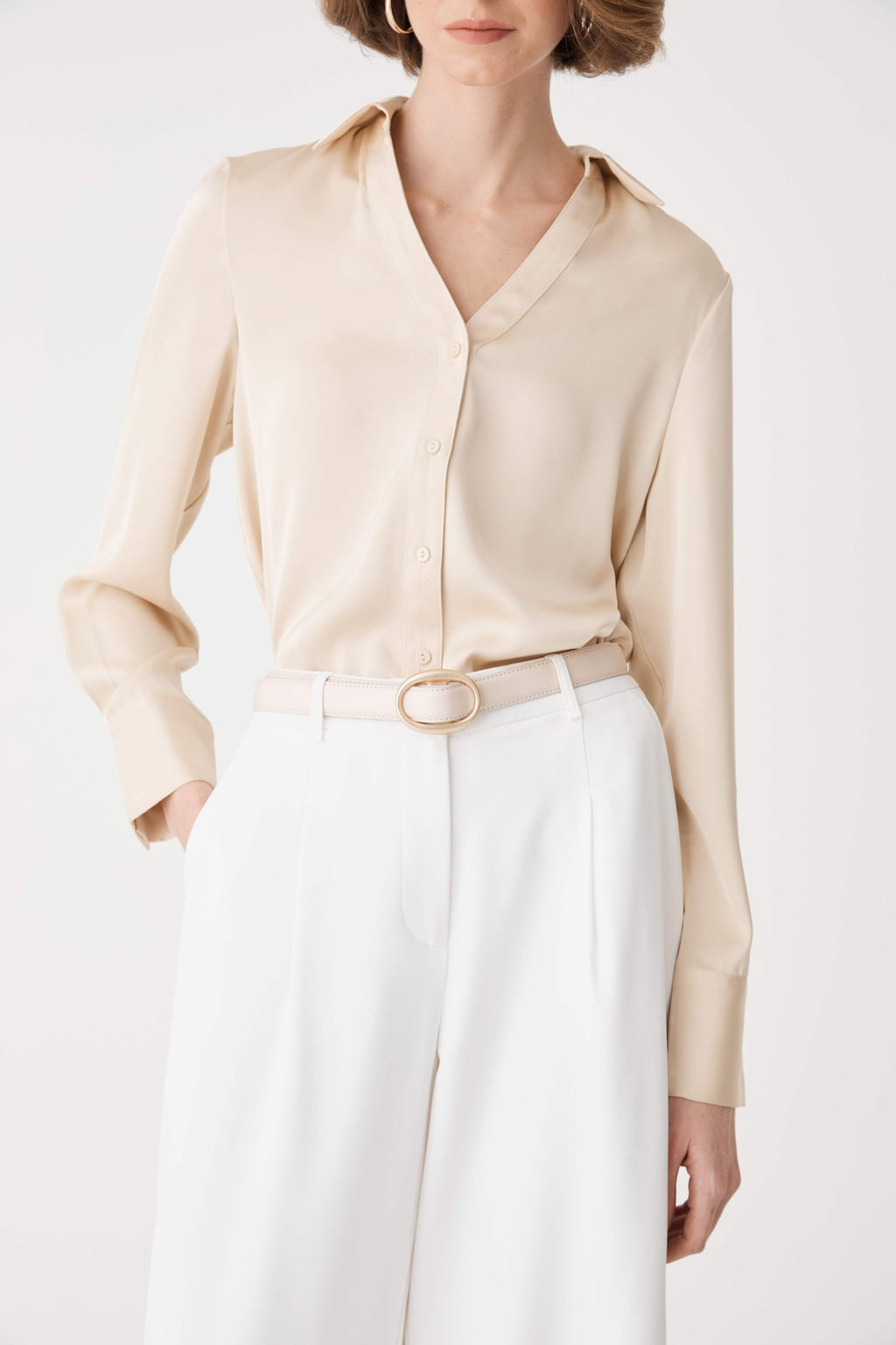 Close-up of the cream Aura Leather Belt oval buckle with leather-wrapped centre insert