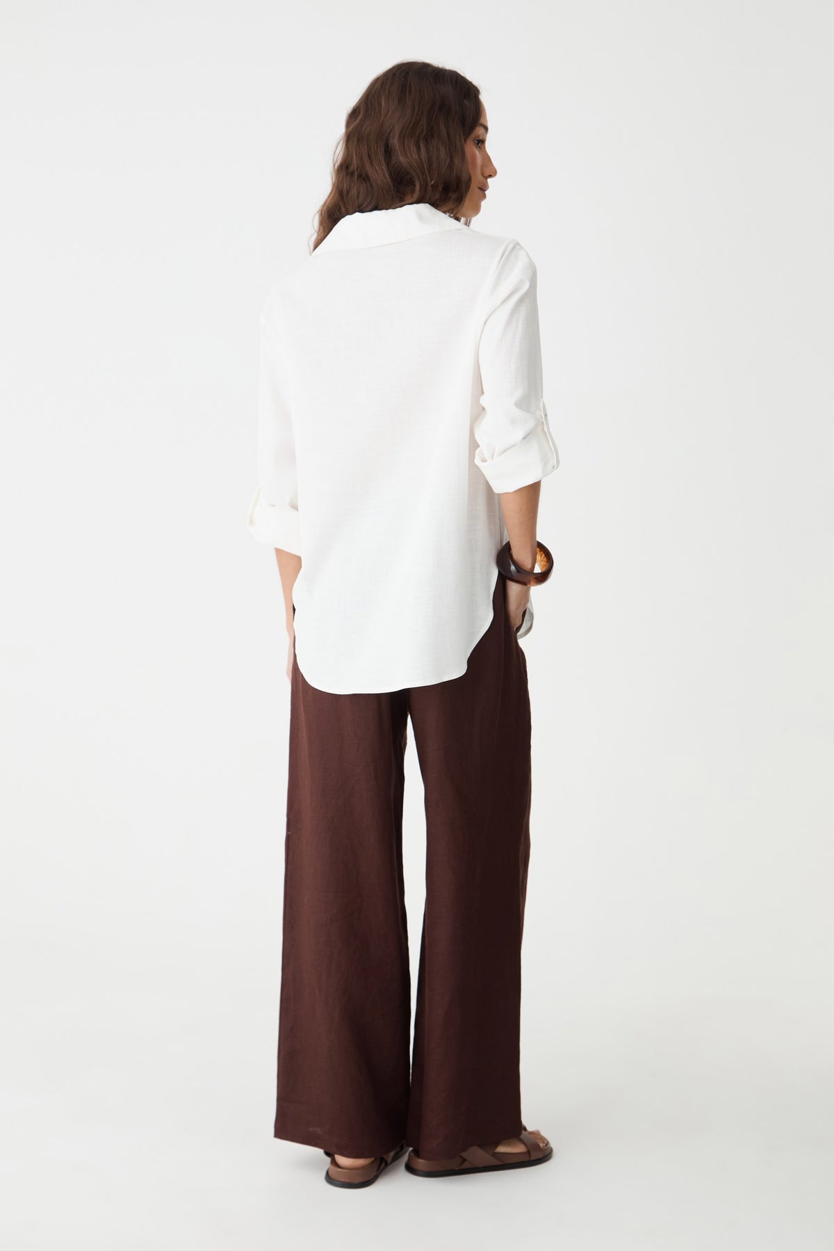 Back view of the dark chocolate linen pants and white shirt